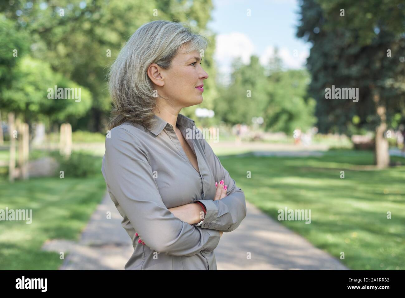 Ritratto esterno positivo della coppia di mezza età della donna, femmina con le braccia incrociate, bel sorriso, sfondo via della città Foto Stock