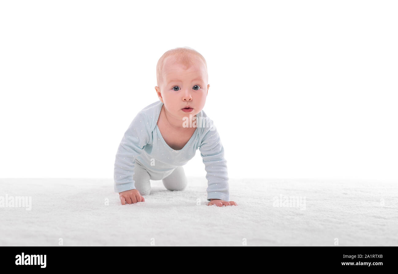 Bambina piccola su un tappeto bianco in una stanza luminosa. Foto Stock