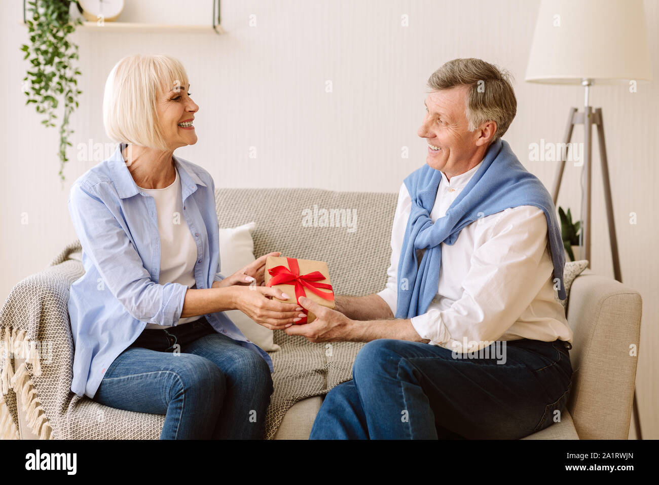 Dono con amore. Uomo maturo dando presente alla moglie Foto Stock