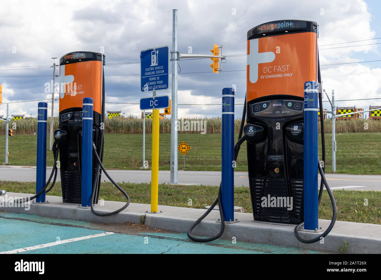 Due stazioni di ricarica per veicoli elettrici ChargePoint vicino all'aeroporto internazionale Pearson di Toronto. Aeroporto in una giornata nuvolosa. Foto Stock