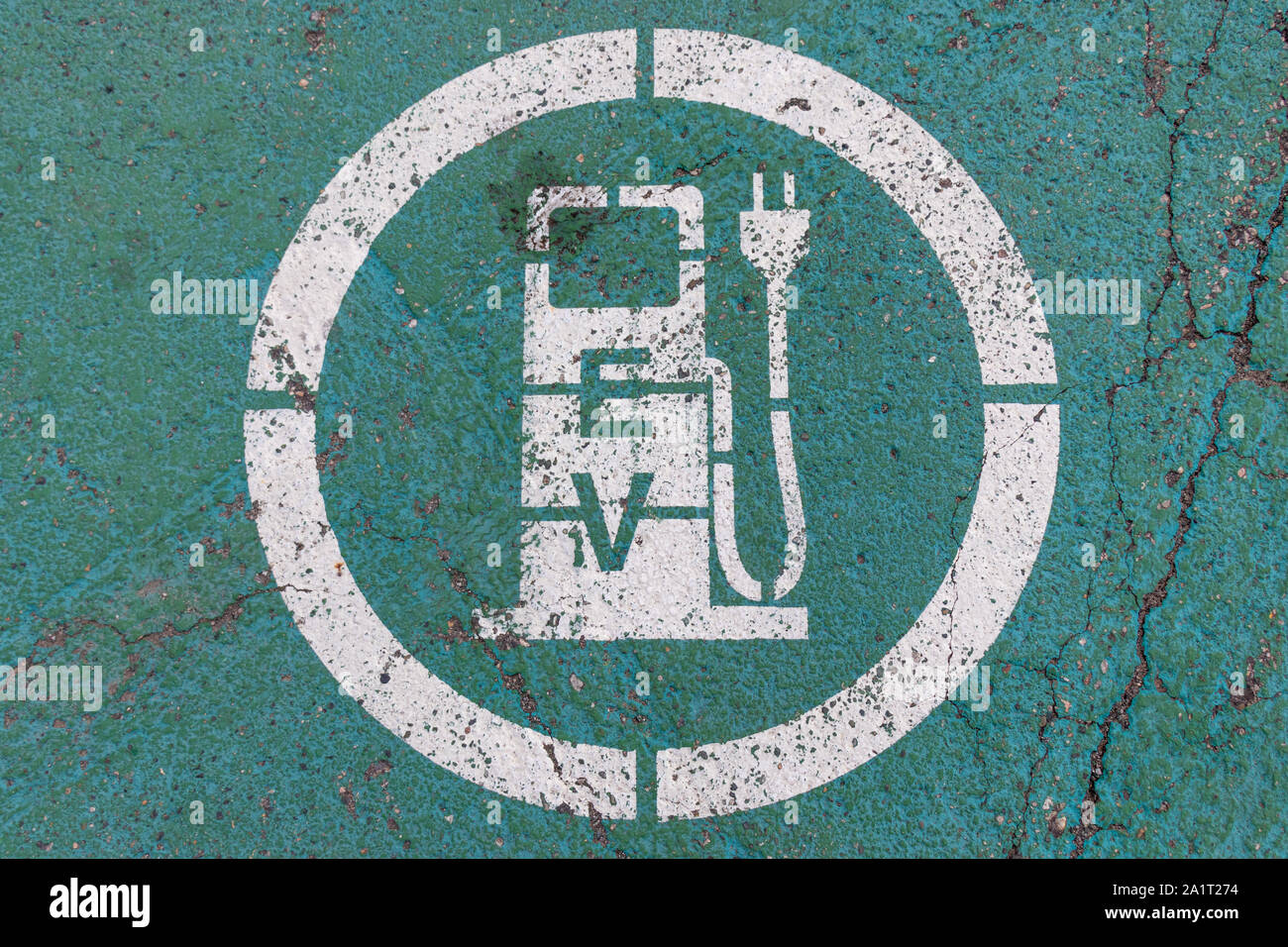 Icona della stazione di carica del veicolo elettrico (EV) su un pavimento verniciato di verde. Foto Stock