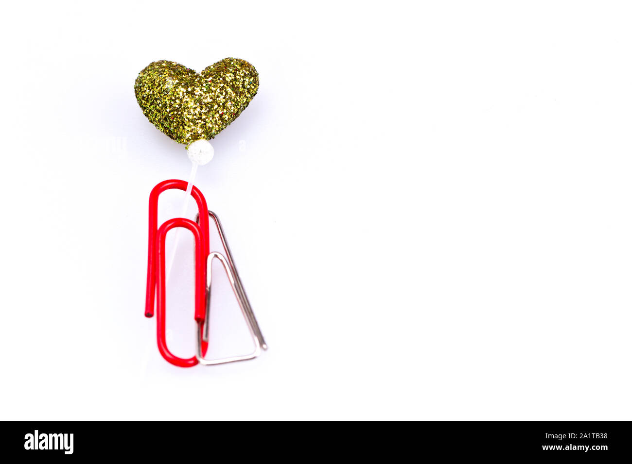 Metallo e plastica rosso paerclip insieme con amore simbolo su sfondo bianco con spazio di copia Foto Stock