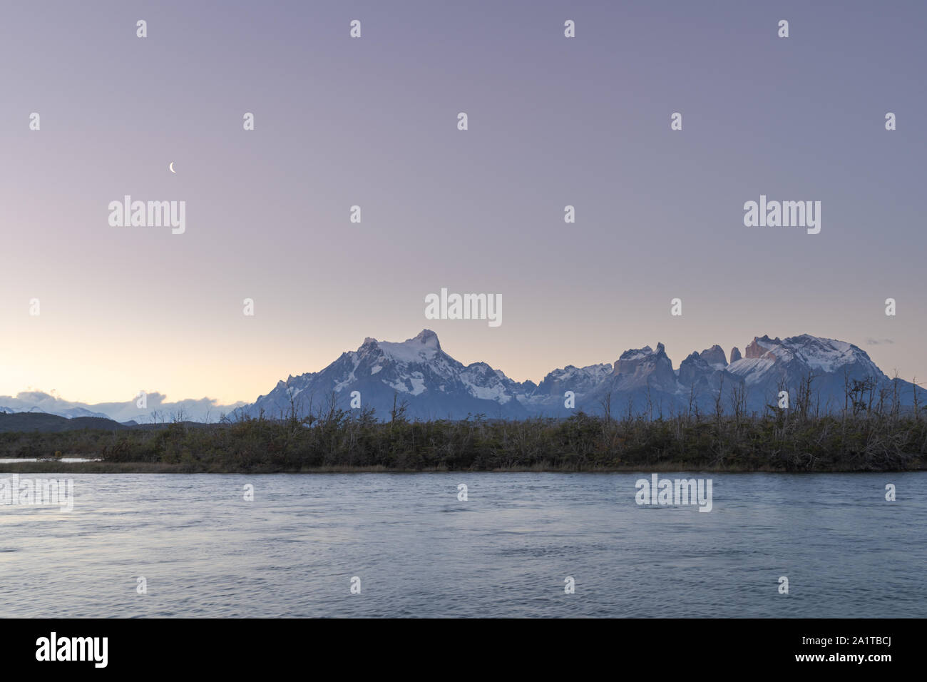 Panorama del massiccio del Paine dal rio area Serrano. Luna crescente nei primi del cielo della sera. Abbondanza di spazio copia. Foto Stock