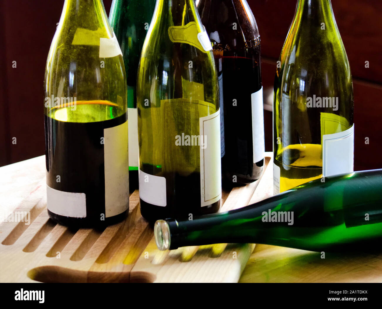 Un tavolo a un partito tiene parzialmente riempito di vino bottiglie, o parzialmente vuoti! Foto Stock