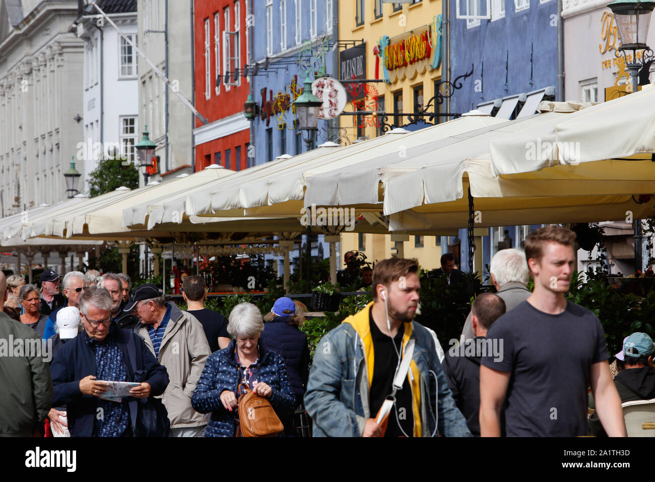 Copenhagen, Danimarca - 4 Settembre 2019: persone valking il Nyhavn street con ristoranti con posti a sedere esterni. Foto Stock