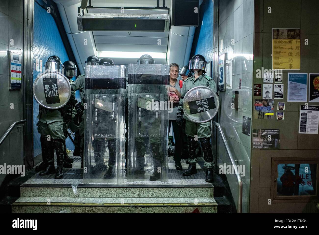 Hong Kong, Cina. 28 Sep, 2019. Un uomo si nasconde dietro un gruppo di polizia a un gate di la Stazione della Metropolitana di Admiralty durante un rally.dimostrazioni continuare a Hong Kong in un'altra notte di protesta durante la commemorazione del quinto anniversario del Movimento ombrello a Tamar Park. Credito: SOPA Immagini limitata/Alamy Live News Foto Stock