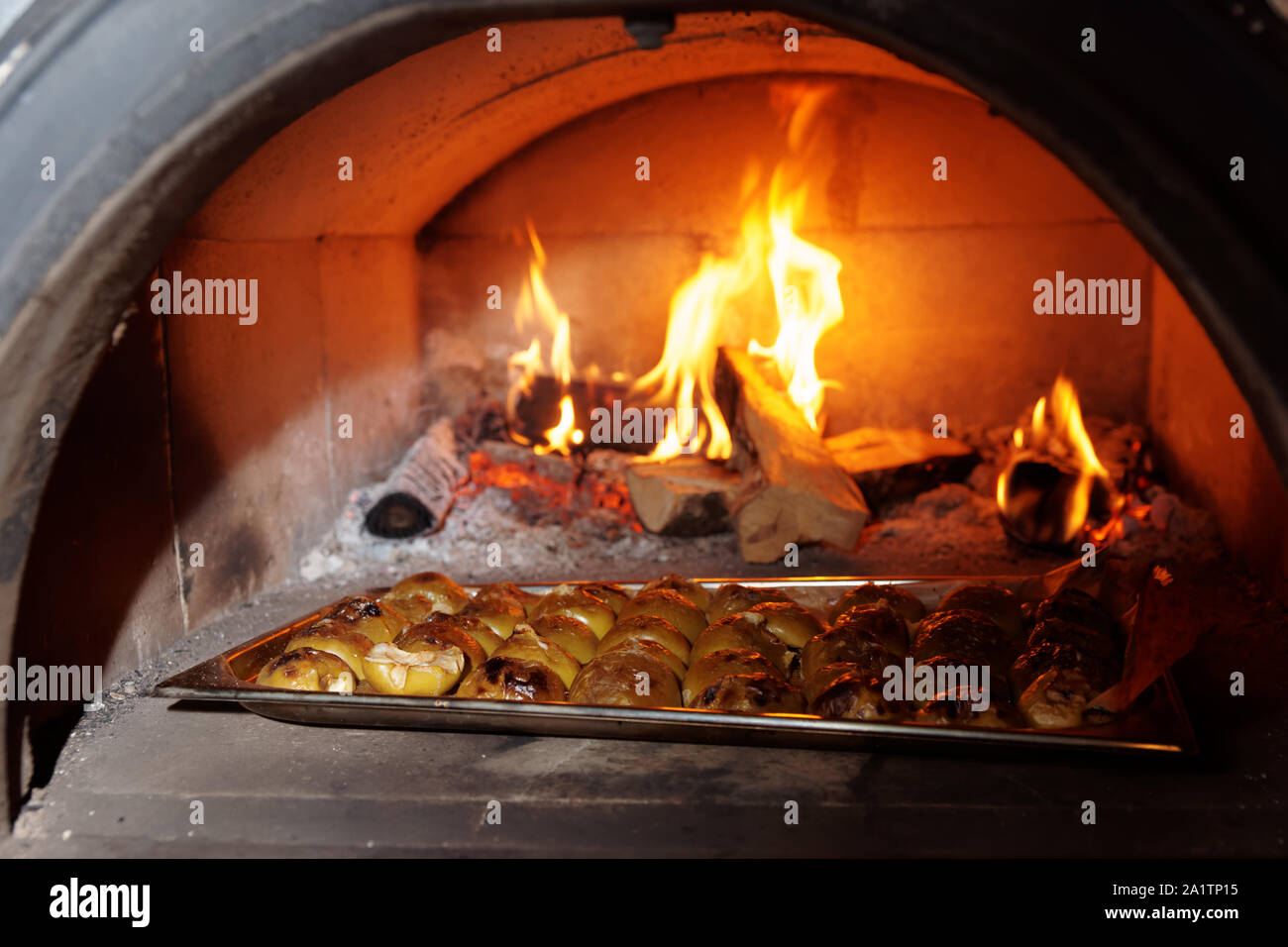 Apple semiparti essendo tostate in forno a legna, cucina professionale di un ristorante Foto Stock