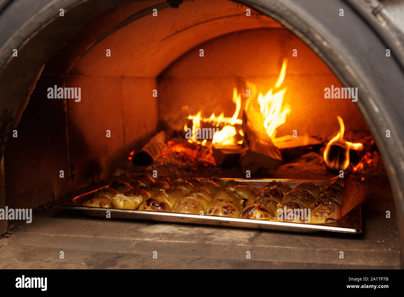 Apple semiparti essendo tostate in forno a legna, cucina professionale di un ristorante Foto Stock