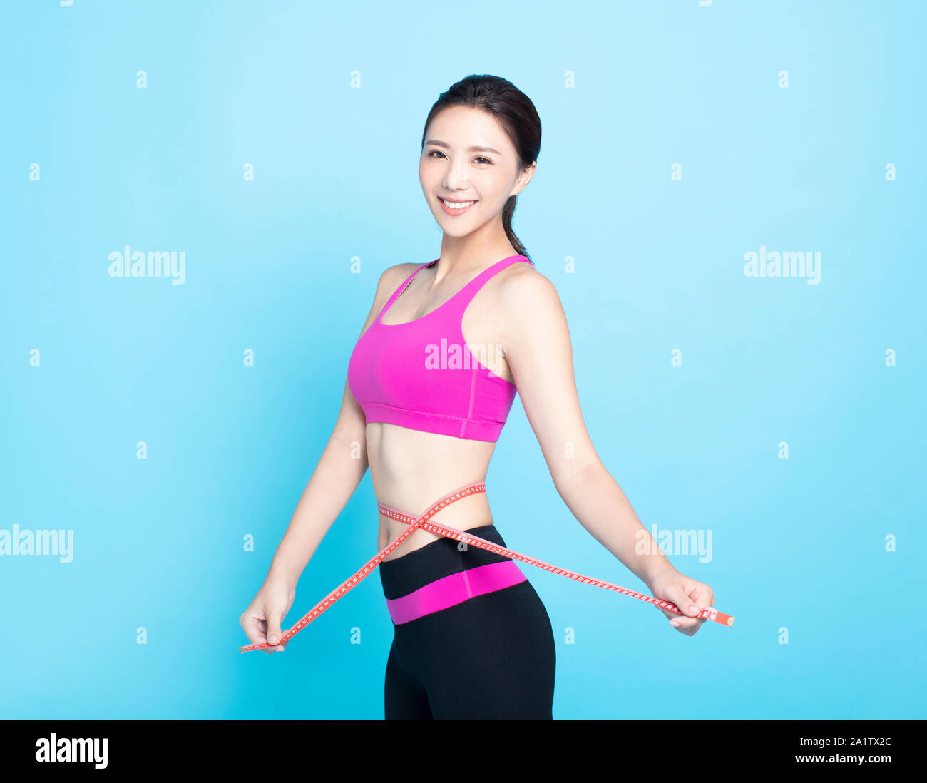 Giovane donna con corpo sottile misurando il suo girovita Foto Stock
