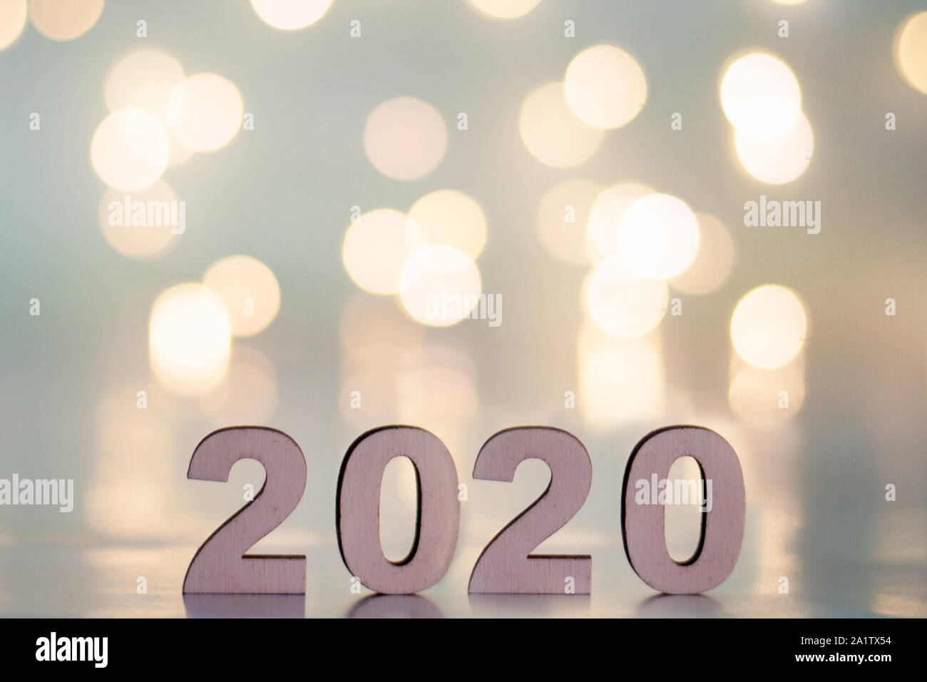 L'iscrizione 2020, Capodanno e Natale, da dietro sfocato punti di luce su uno sfondo blu. Natale e vacanze Foto Stock
