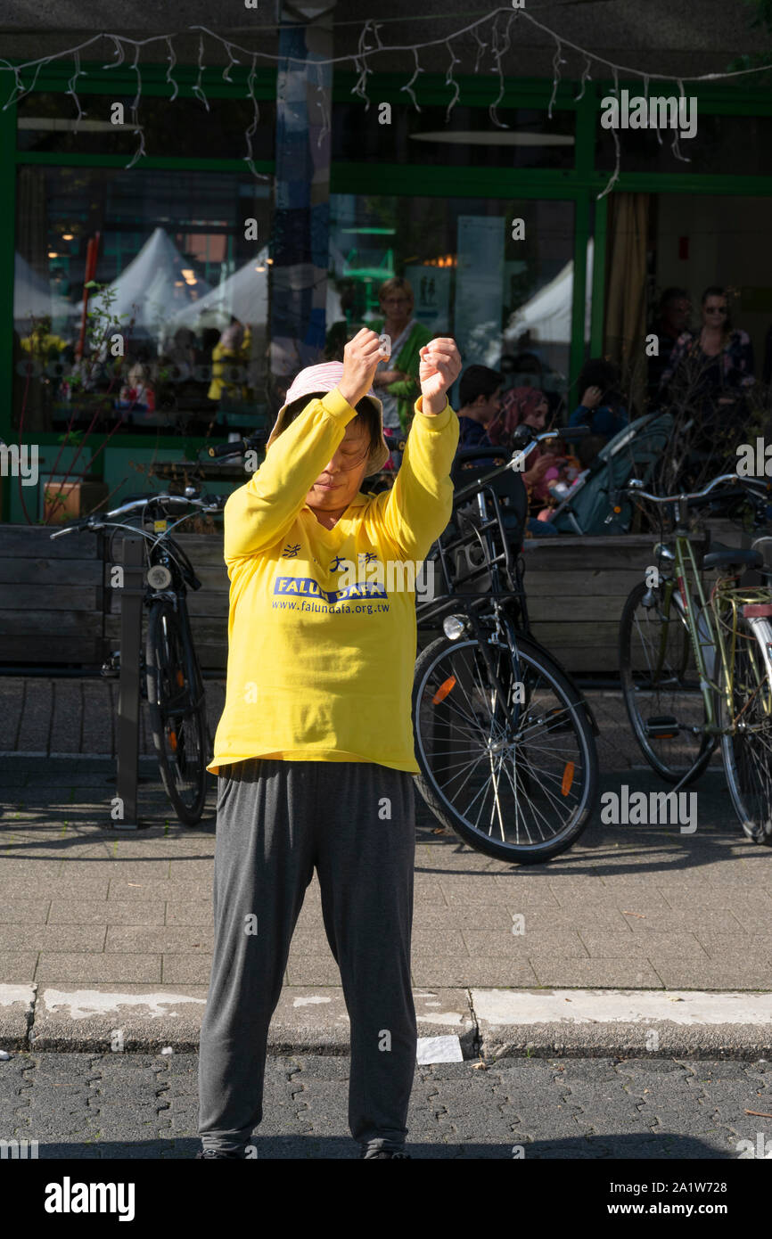 Sint Niklaas, Belgio, 8 settembre 2019, Orientale donna con cappello praticato Falun Dafa, alza le braccia delicatamente nell'aria Foto Stock