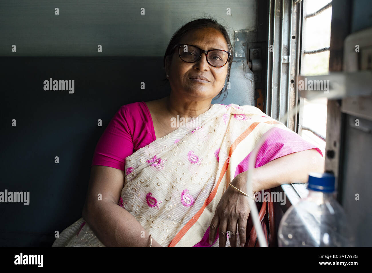 Una donna indiana sta viaggiando su un treno indiano da New Delhi a Varanasi. Foto Stock