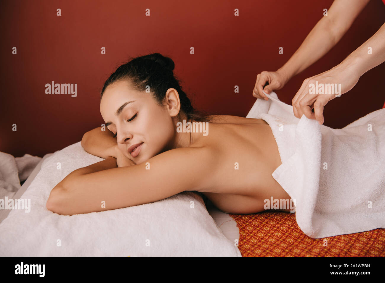 Massaggiatore decollare asciugamano da donna attraente in spa salone Foto Stock