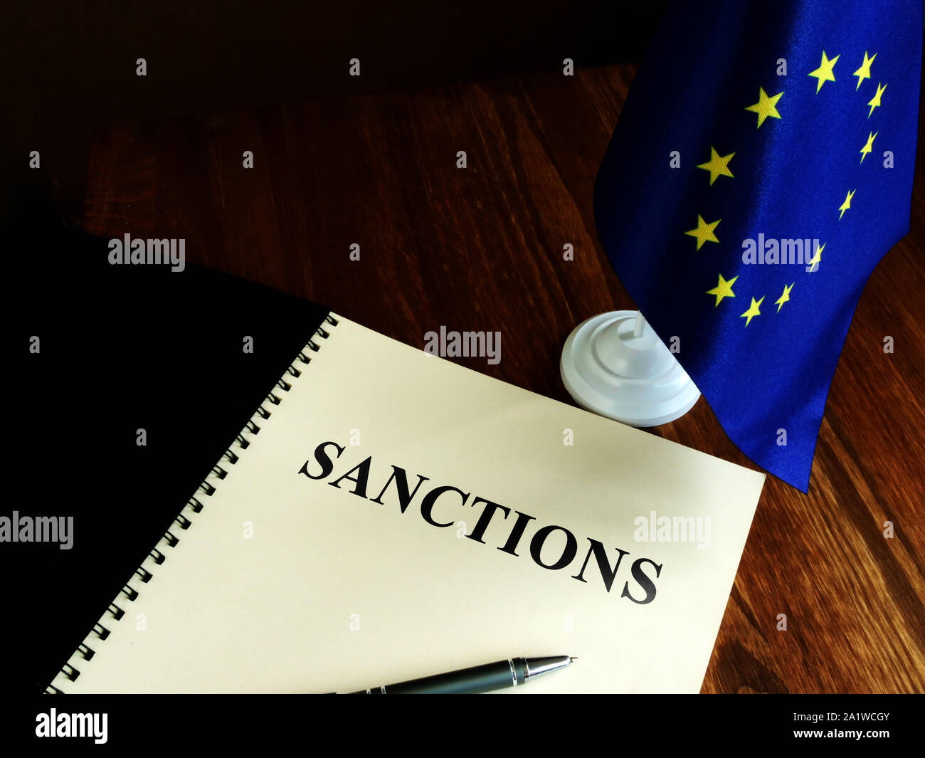 Elenco sanzioni e bandiera UE sulla scrivania. Foto Stock