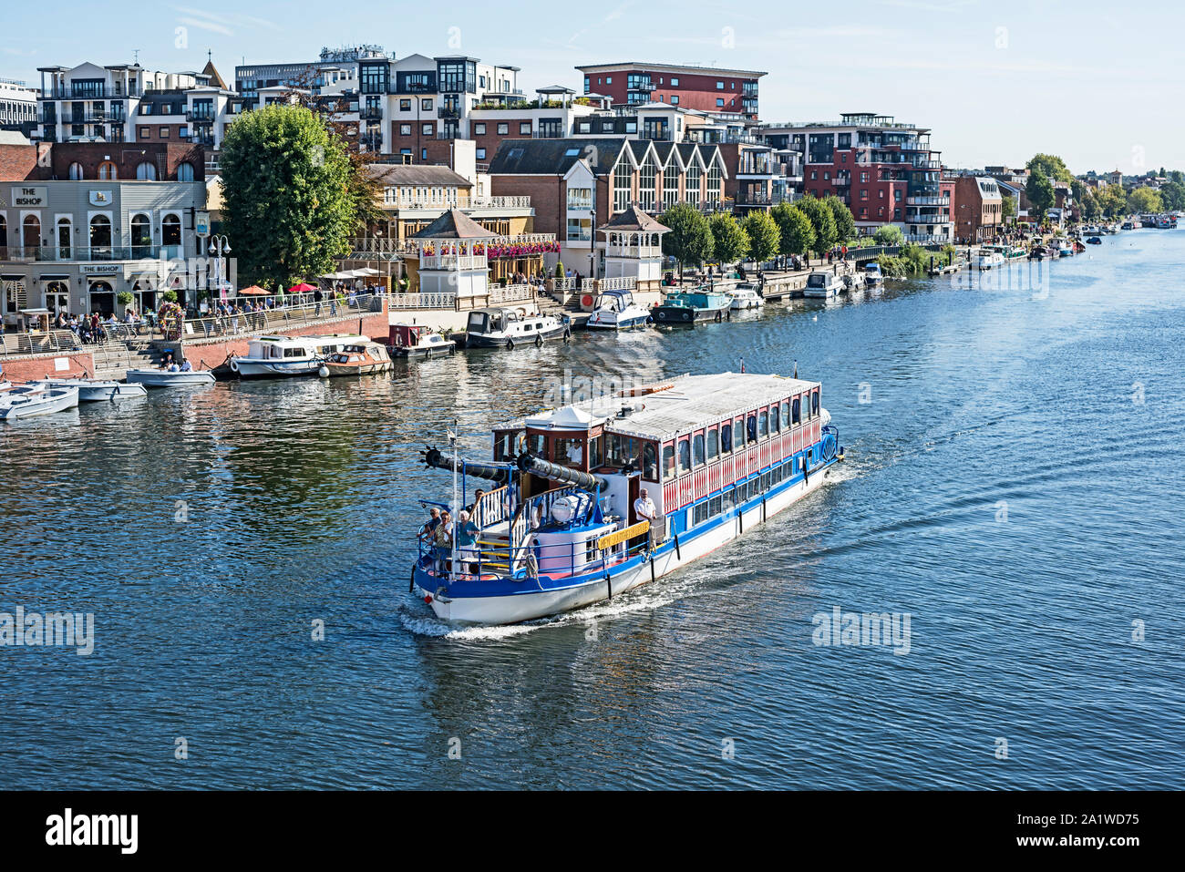 Di trasporto turistico di passeggeri imbarcazione da diporto sul fiume Tamigi con ormeggiate imbarcazioni da diporto e di persone lungo la riva del fiume in background. Foto Stock