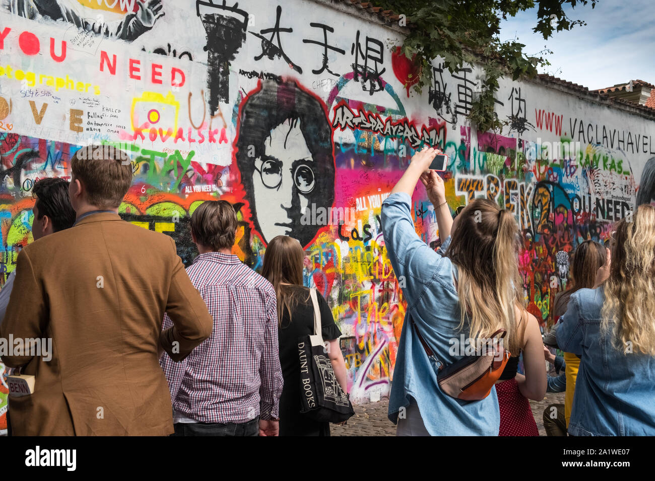 Muro di John Lennon, Praga, Repubblica Ceca. I turisti la visualizzazione di parole e di opere d'arte, Grand Priory Square, Mala Strana di Praga. Foto Stock