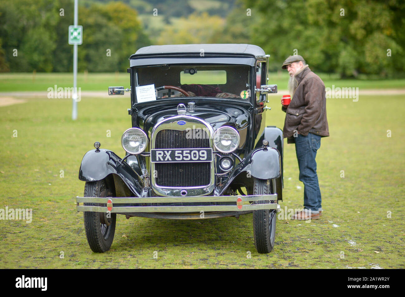 Un uomo si ammira una Ford modello A in corrispondenza di una classic car raduno al Castello di Sudeley, Cotswolds, dove diversi classic car proprietari hanno braved il meteo per mostrare i loro veicoli. Foto Stock