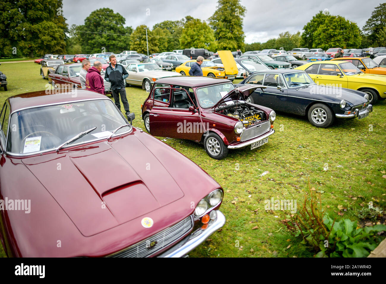 Gli uomini stanno intorno un mini e chat in un auto classica raduno al Castello di Sudeley, Cotswolds, dove diversi classic car proprietari hanno braved il meteo per mostrare i loro veicoli. Foto Stock