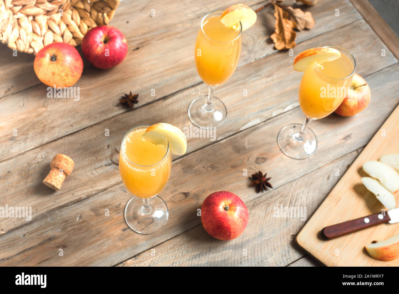 Apple Mimosa Cocktail in bicchieri alti e mele biologiche su legno. Caduta stagionale bevande per vacanze - champagne cocktail mimosa con le mele. Foto Stock