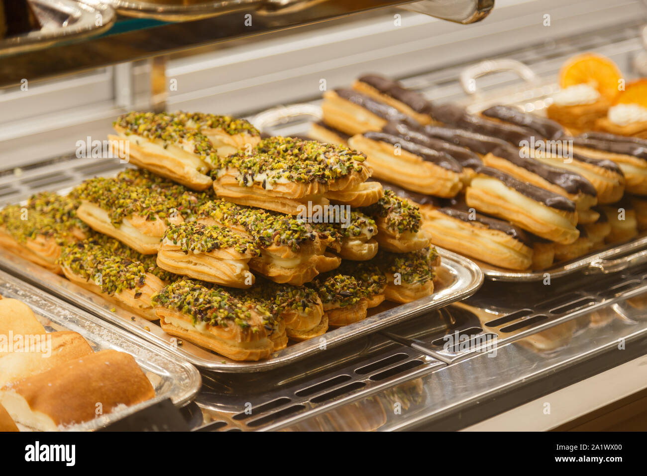 Eclairs e altri dolci in vetrina al cafe Foto Stock