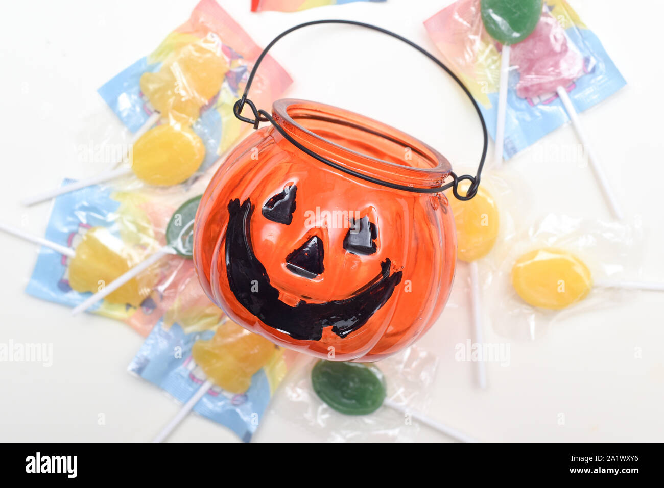 Zucca di Halloween con dolcetto o scherzetto dolci caramelle su sfondo bianco Foto Stock