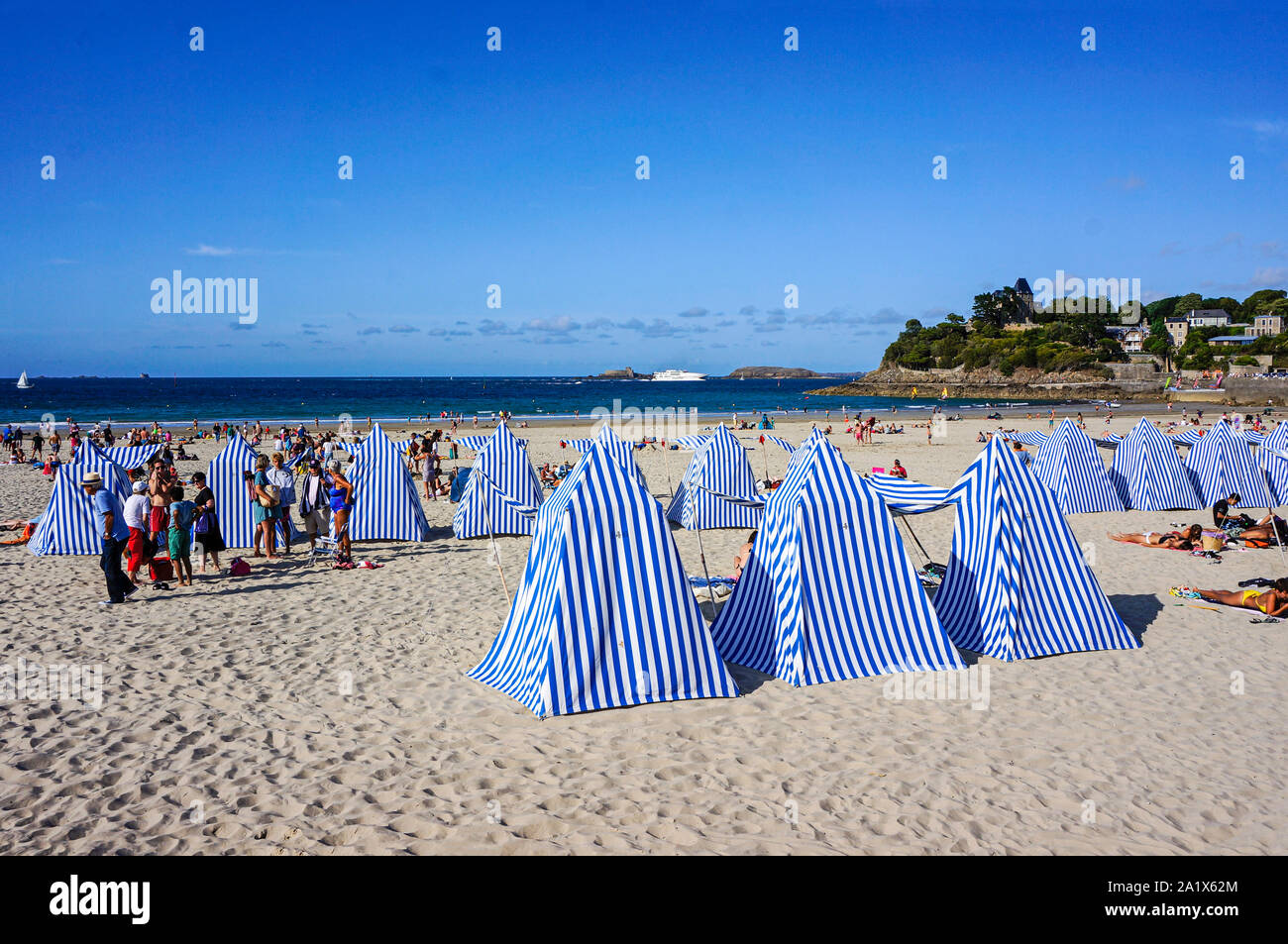 Blu tende a strisce e bagnanti in spiaggia a città Dinard Britannia Francia Europa Foto Stock