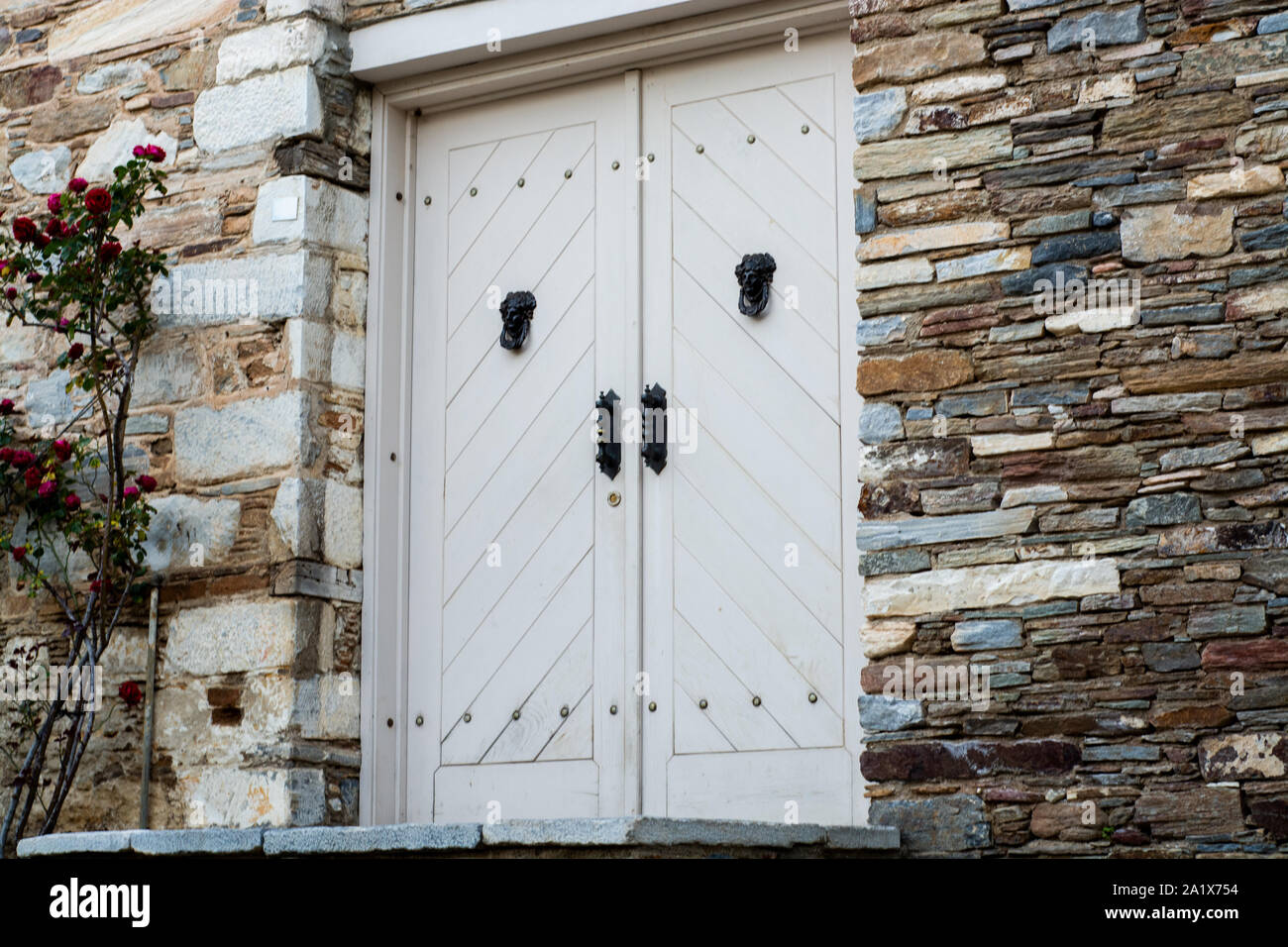 Chiusa medievale porta di legno su un muro di pietra Foto Stock