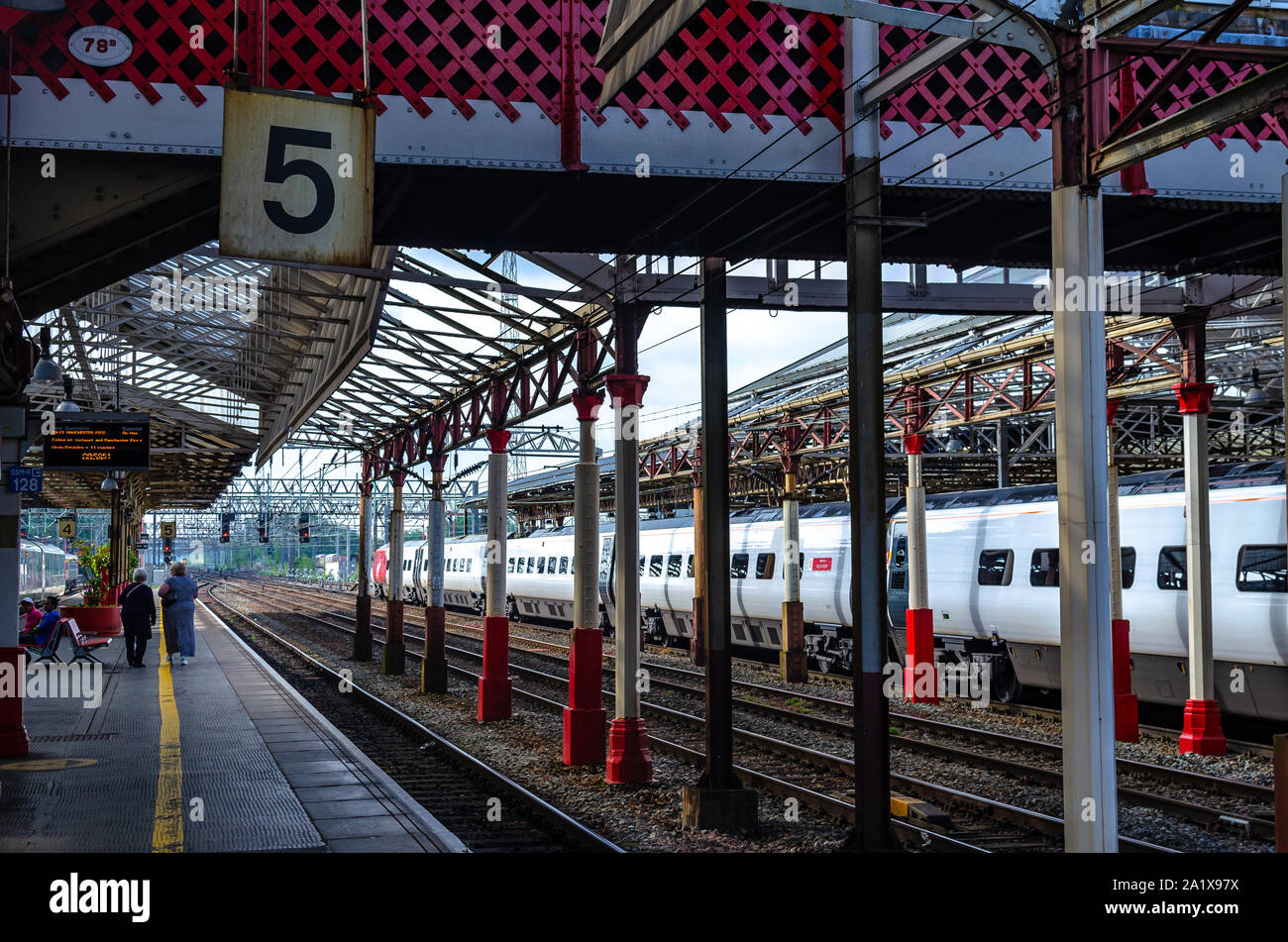 Alla stazione ferroviaria di Crewe e pendolari sulla piattaforma numero 5. Crewe, Cheshire, Inghilterra. Foto Stock
