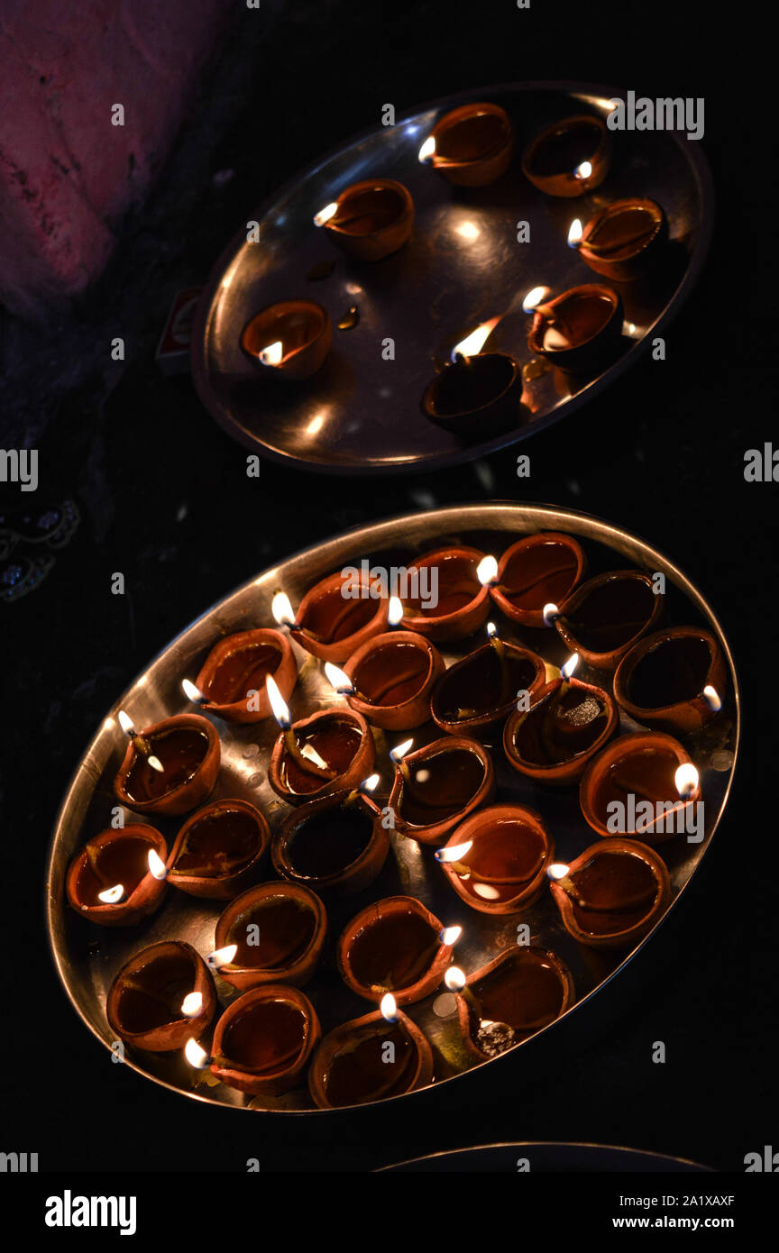 Una piastra è che è caricata con rose e candela su indian festival diwali deepawali con il fuoco isolato sul tavolo Foto Stock