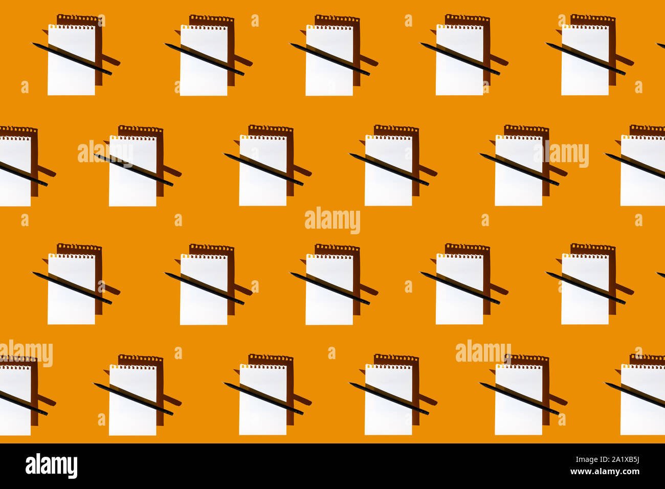 Un modello di blank Notepad, matita nera e il disco di ombre su un brillante sfondo giallo Foto Stock