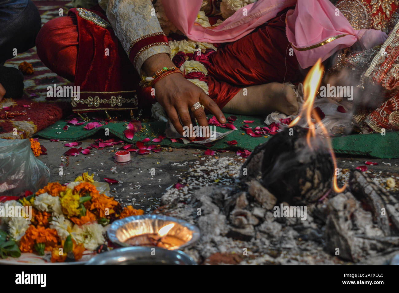 Appena prima di groom andando a mettere il colore rosso(sindoor) sulla testa di sposa in uno dei rituali nel matrimonio indiano. Foto Stock