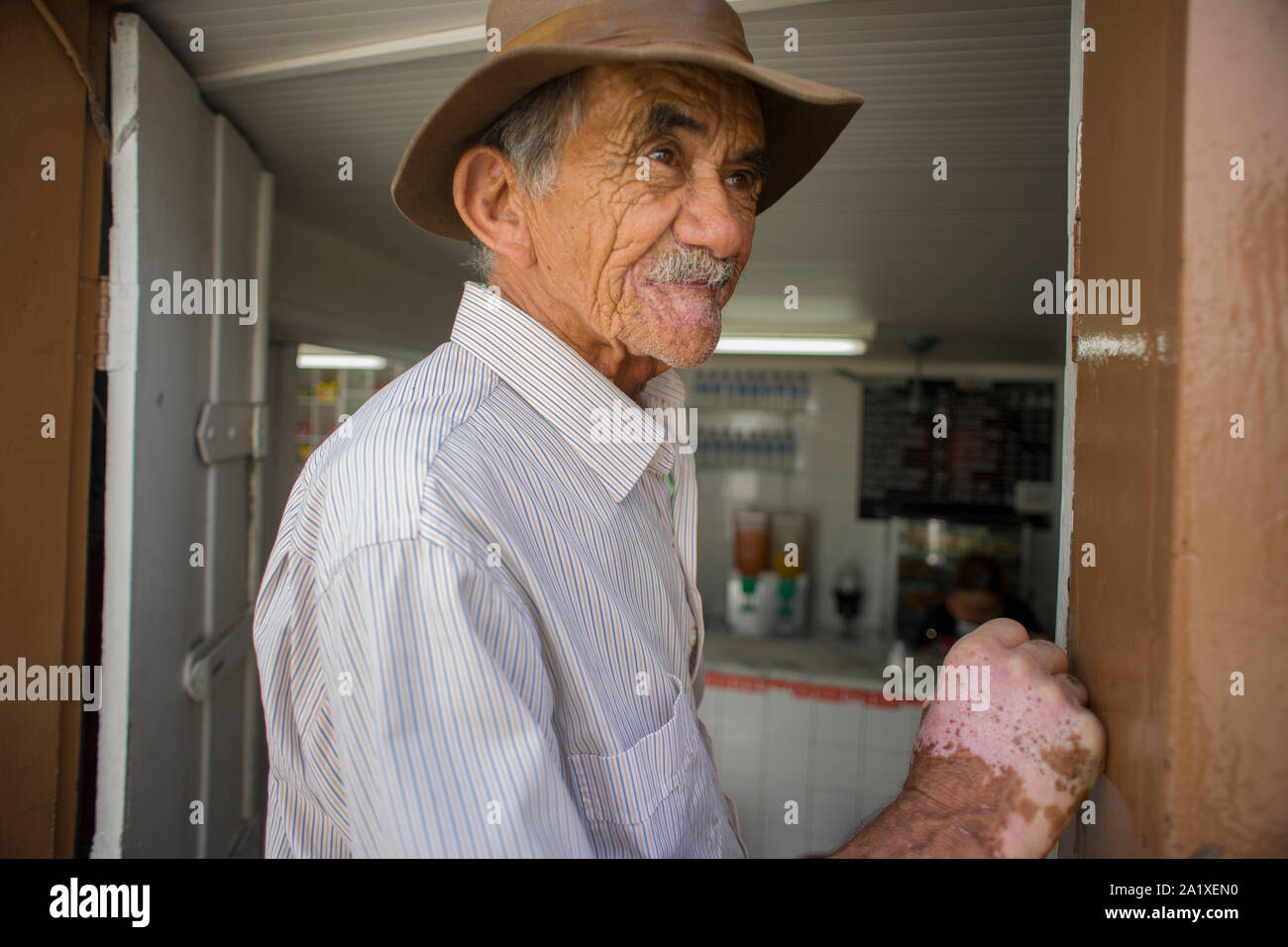 Diamantina, Minas Gerais, Brasile - 26 Gennaio 2016: Paese uomo con la vitiligine malattia nella porta di un bar tradizionale che guarda lontano per la strada Foto Stock