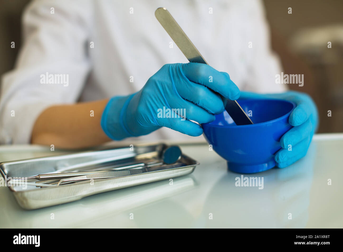 Primo piano delle mani femminili medico dentista impastare la massa del pallone. Foto Stock