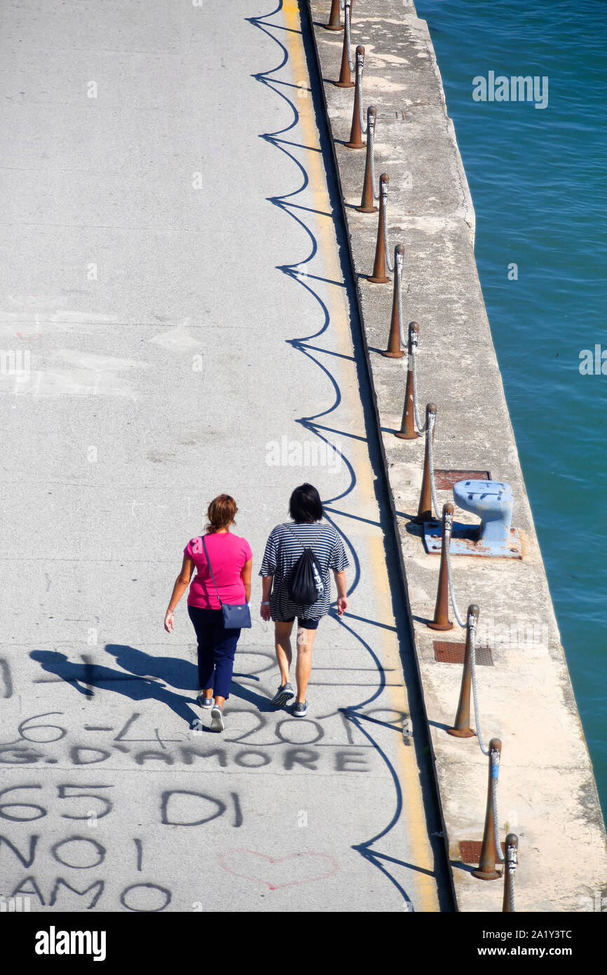 Vista guardando verso il basso le due pedoni camminare accanto a un fiume di Pescara (Italia). Foto Stock