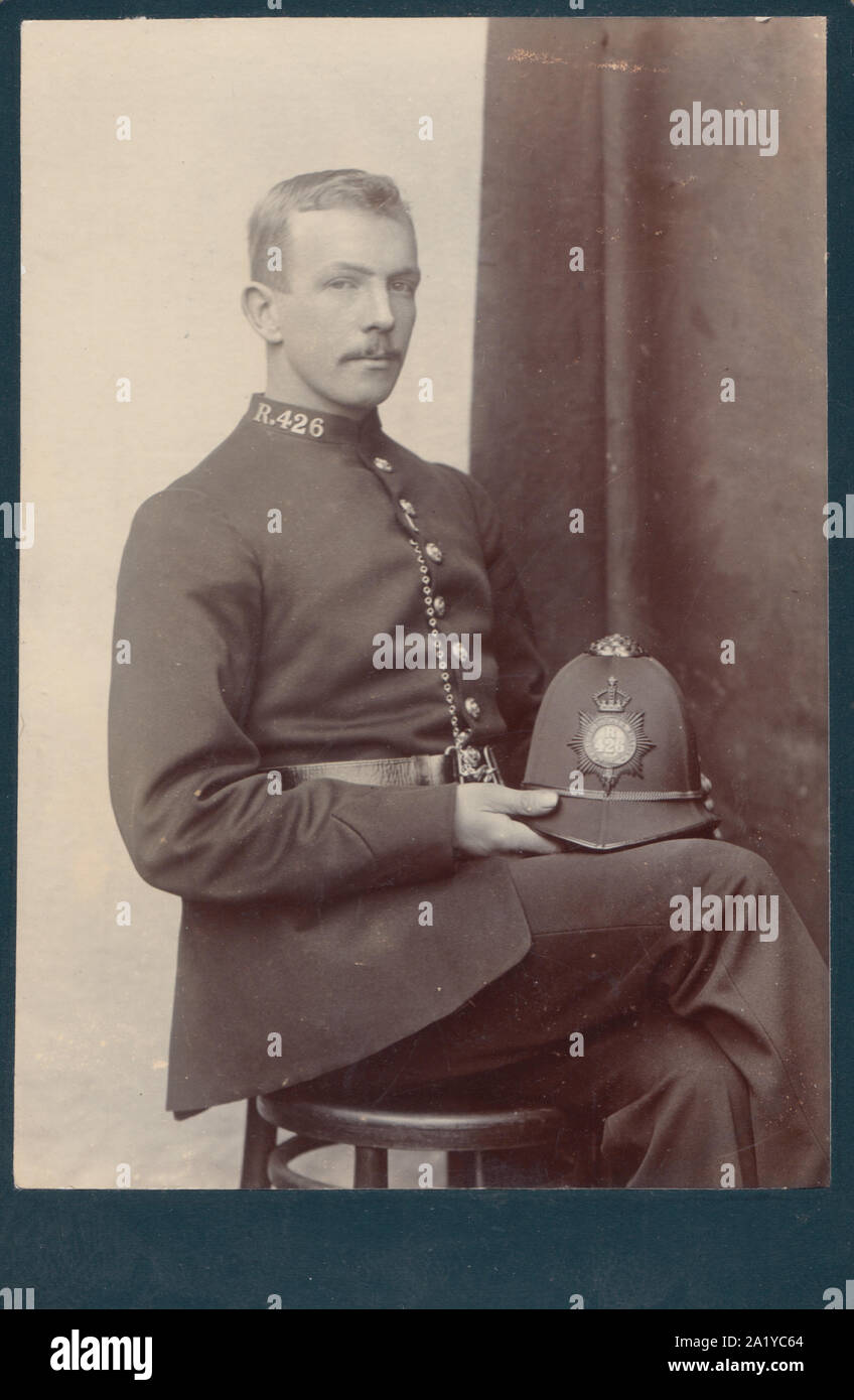 Armadio vittoriano Card che mostra un British funzionario di polizia si sedette tenendo la sua polizia casco. Collare n. R.426 Foto Stock