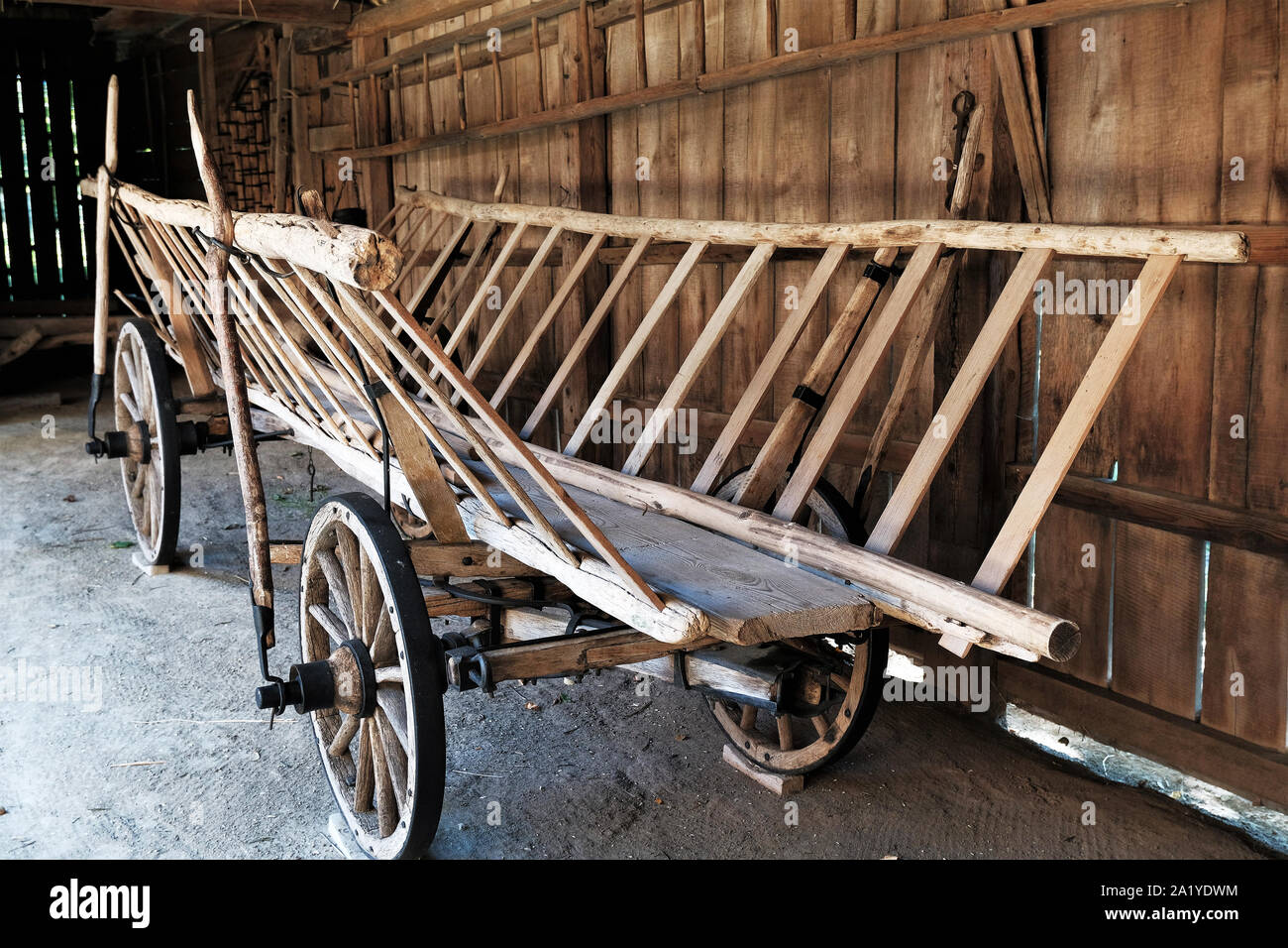 Vecchio cavallo di legno contadino carro parcheggiato in un capannone Foto Stock