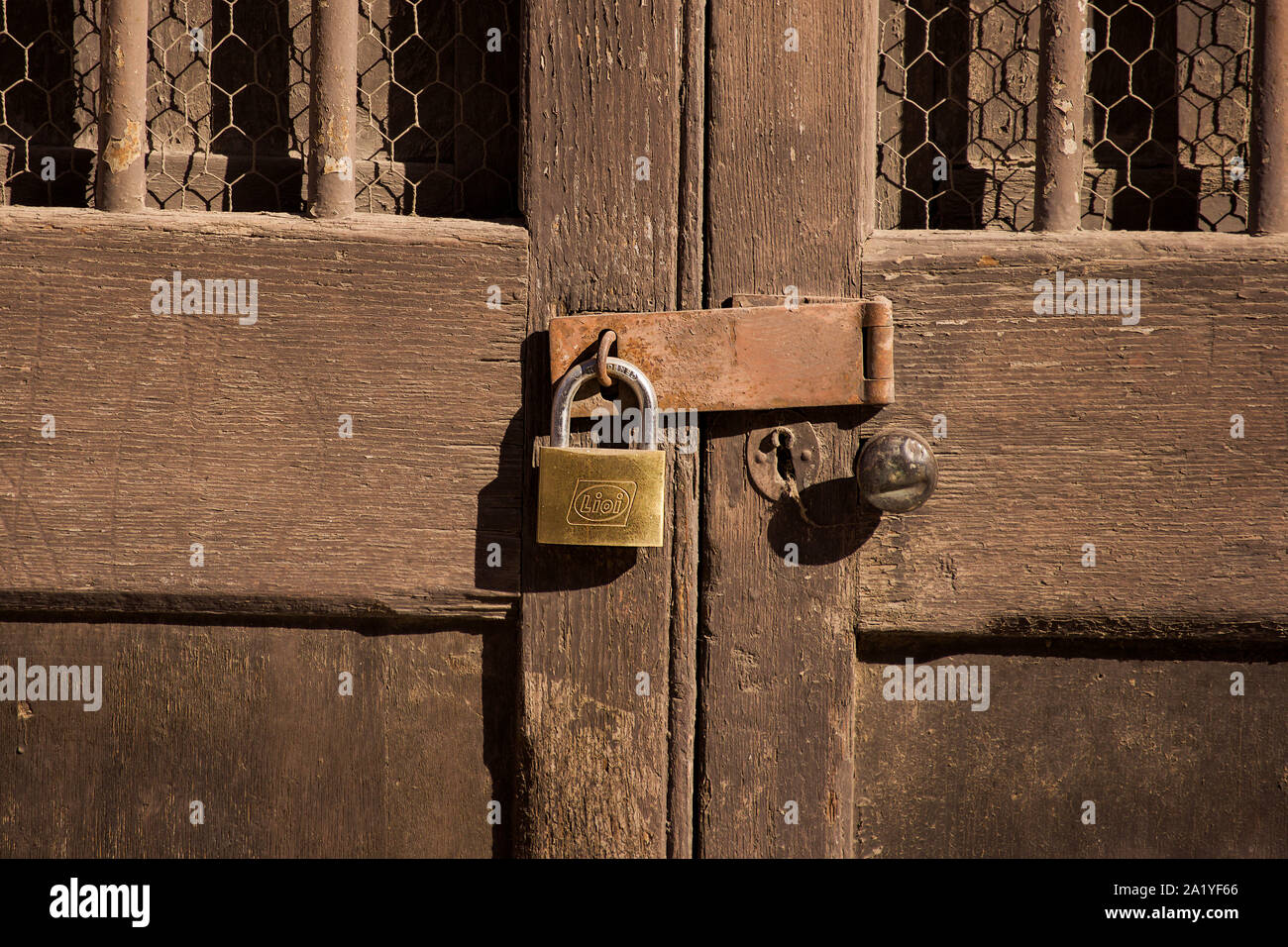 Lucchetto su una vecchia porta di legno, hard light, contrasto Foto Stock