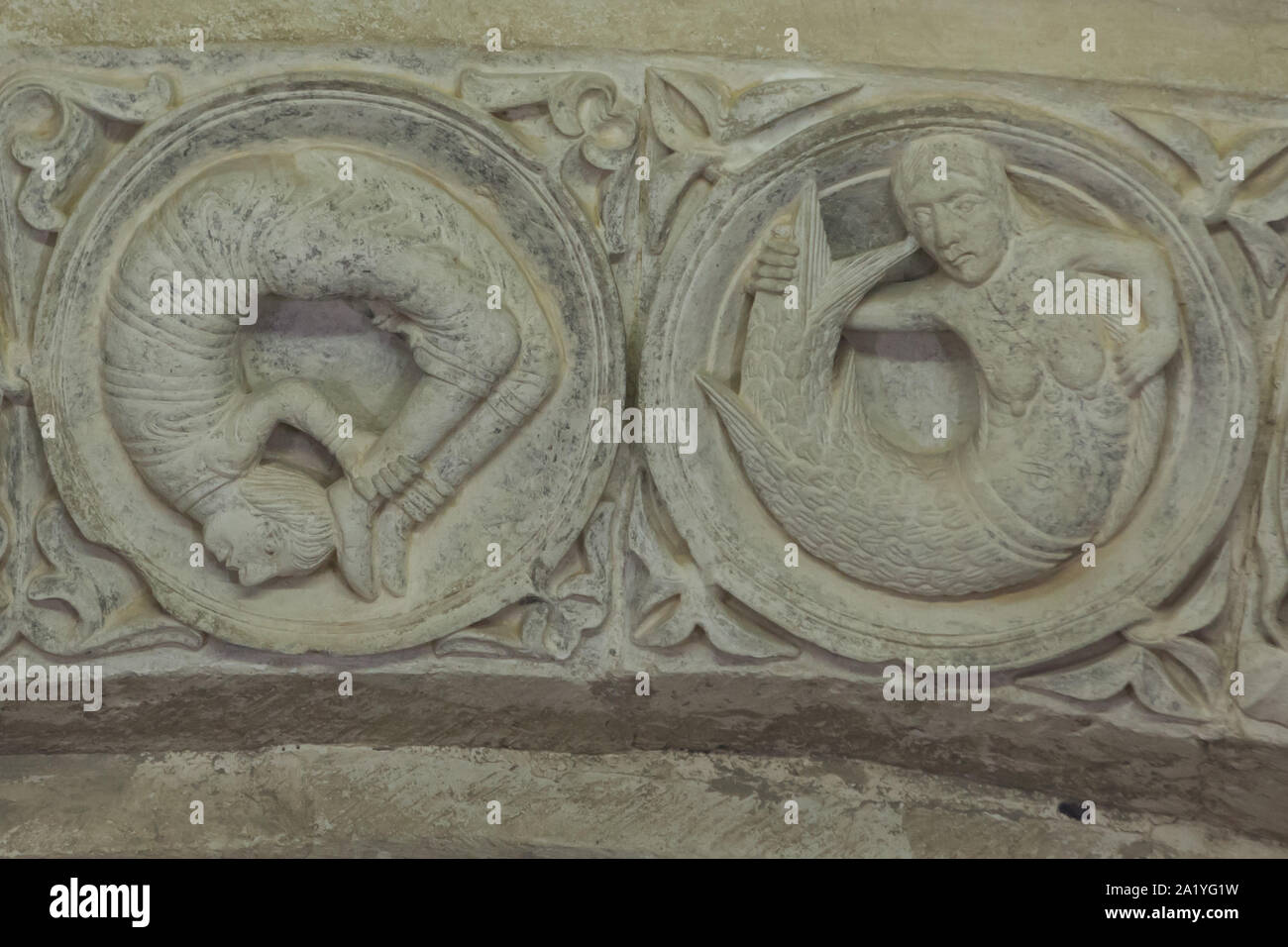 Acrobat medievale e una sirena raffigurata nel timpano romanico risale al xii secolo nel nartece della basilica di Santa Maria Maddalena (Basilique Sainte-Marie-Madeleine de Vézelay) di Vézelay Abbey (Abbaye Sainte-Marie-Madeleine de Vézelay) in Vézelay, Borgogna, Francia. Foto Stock