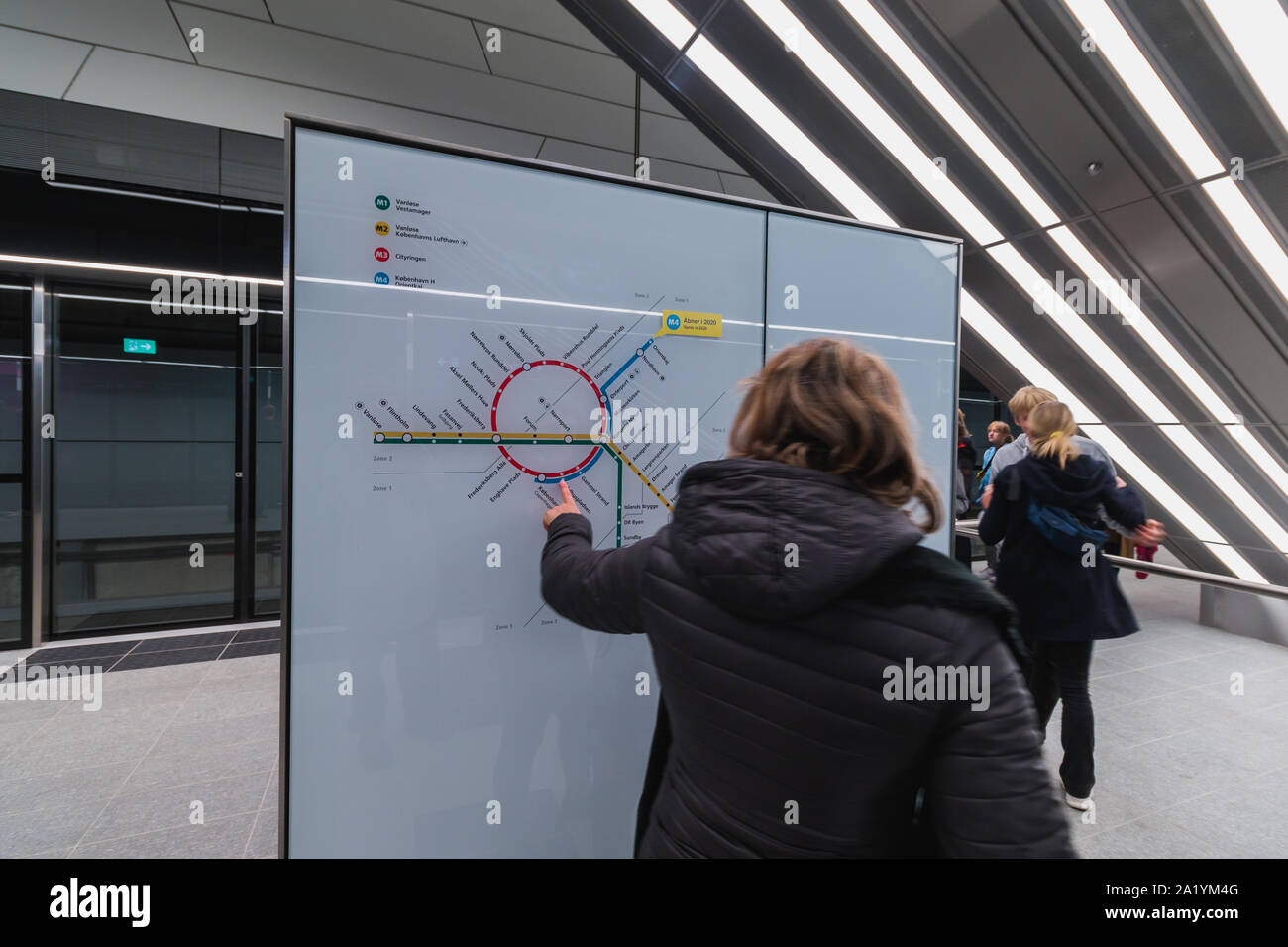 Copenaghen, Zelanda Danimarca - 29 9 2019: Donna è puntare il dito alla mappa della nuova M3 Cityringen metro linea della metropolitana di Copenaghen, Danimarca Foto Stock