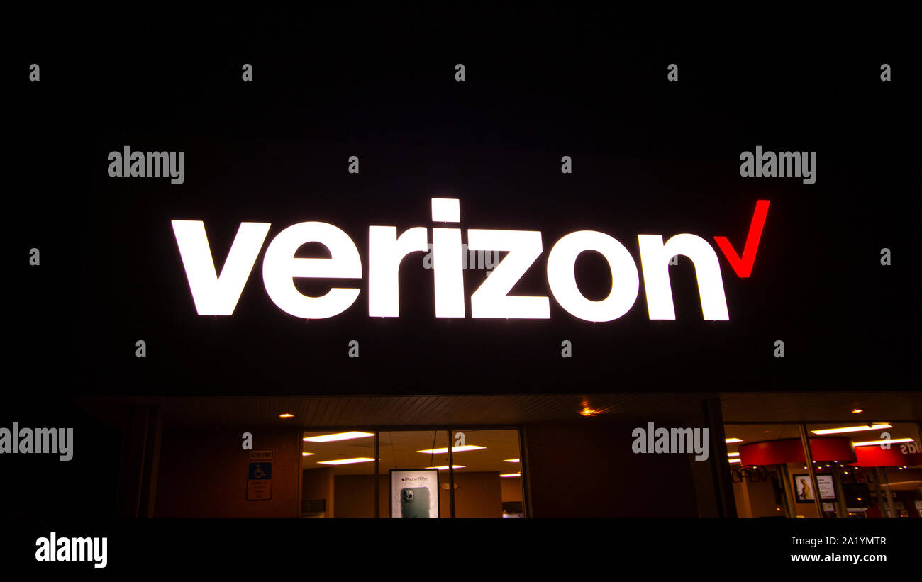 Segno di Verizon incandescente al buio a ALBA Foto Stock