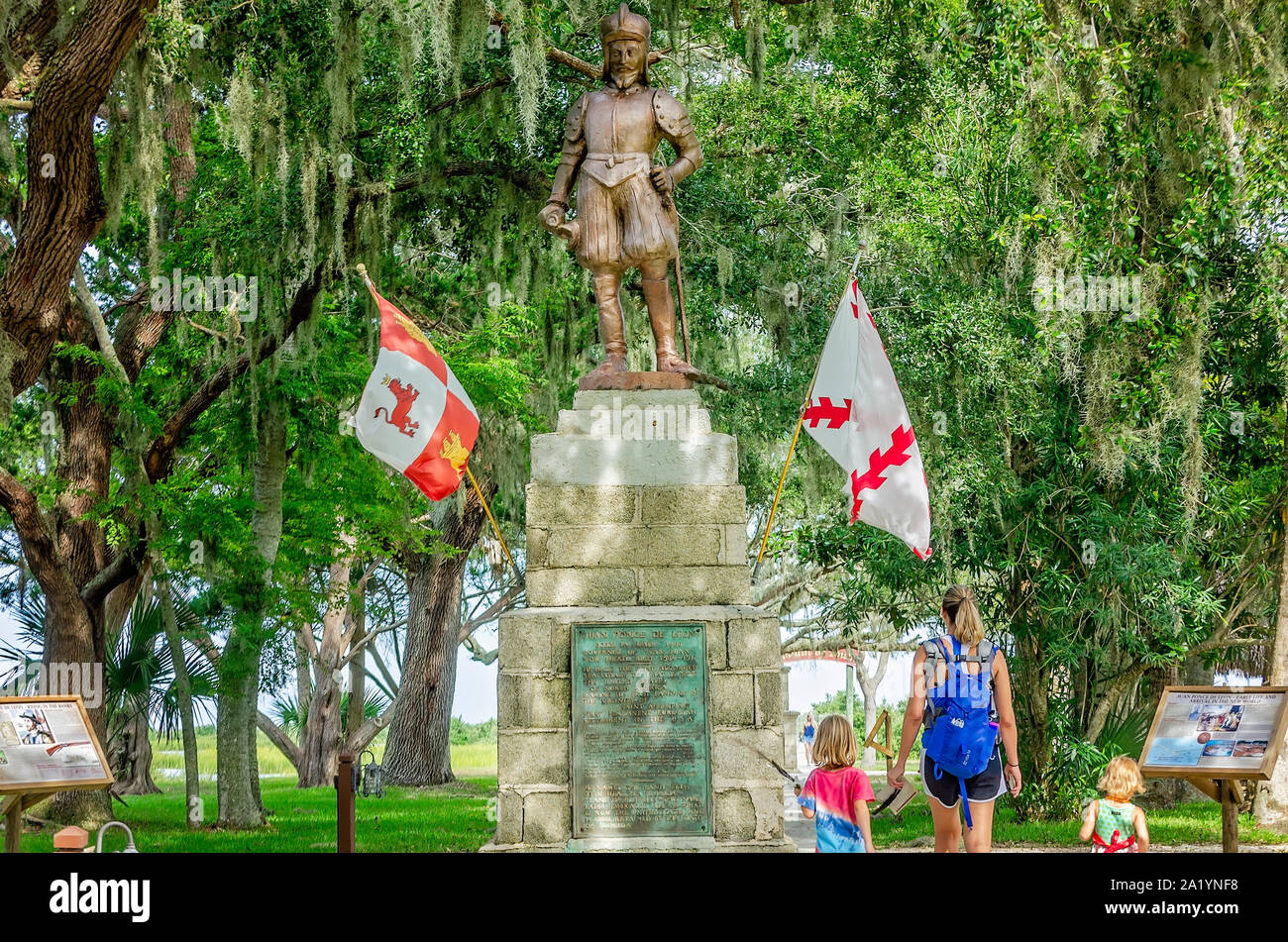 Una madre e i suoi figli a piedi passato una statua di Ponce de Leon a Ponce de Leon la fontana della giovinezza del Parco Archeologico di Sant'Agostino, Florida. Foto Stock