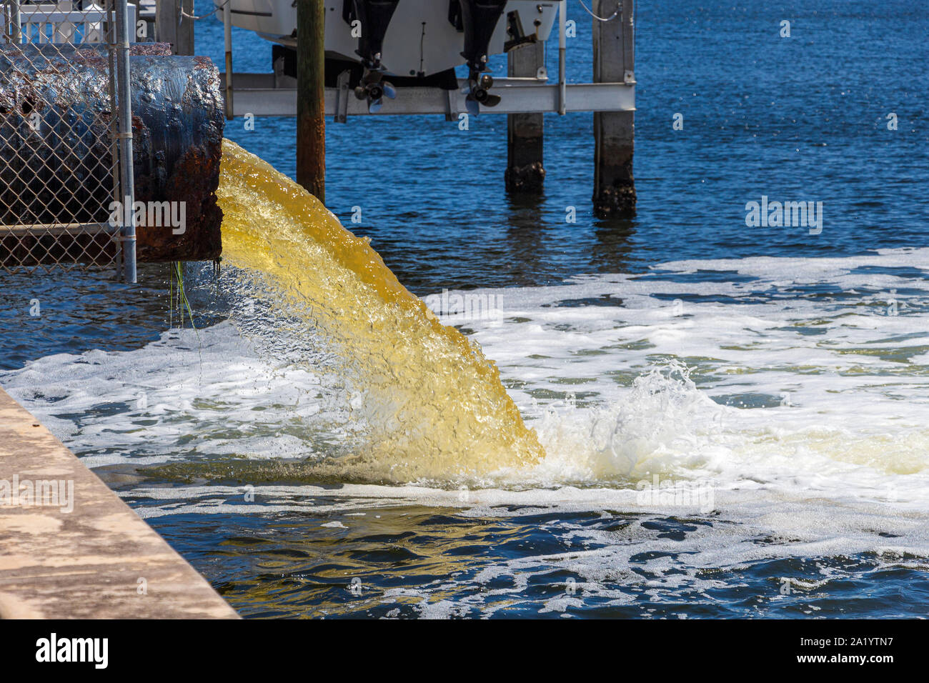 Materie non trattata acqua di colore giallo o il liquame viene pompato in un lago blu - Hollywood, Florida, Stati Uniti d'America Foto Stock