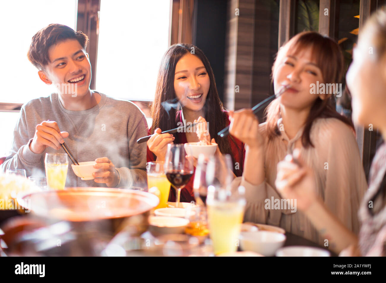 Felice giovani amici potrete gustarvi la cena in hot pot restaurant Foto Stock