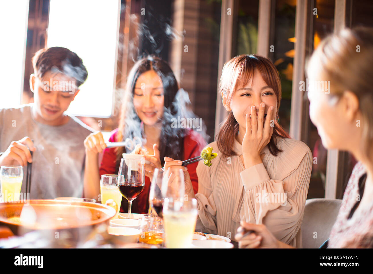 Felice giovani amici potrete gustarvi la cena in hot pot restaurant Foto Stock