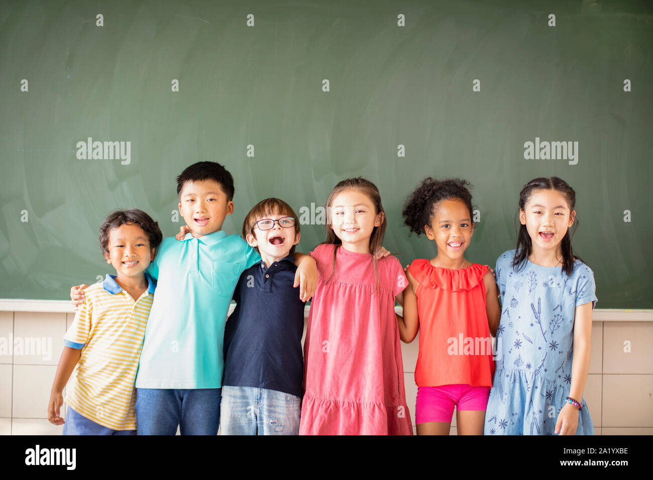Multi-gruppo etnico dei bambini in età scolare in piedi in aula Foto Stock