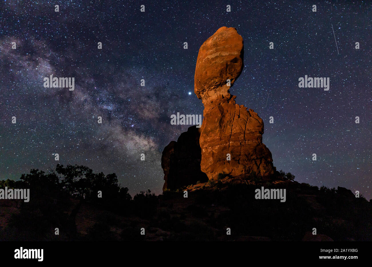 La Via Lattea e 4 stelle cadenti dietro la roccia equilibrata ain Arches National Park nello Utah. Foto Stock
