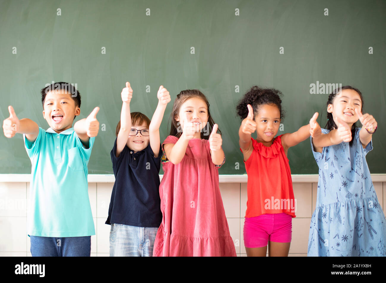 Multi-gruppo etnico dei bambini in età scolare in piedi in aula Foto Stock