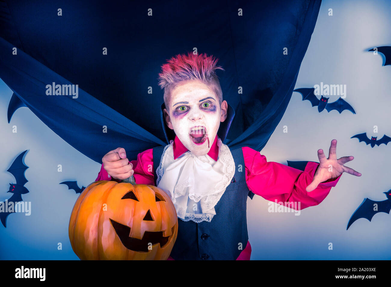 I bambini di Halloween. Spooky ragazzo con un costume di Halloween di un vampiro Dracula con zucca di Halloween jack o lantern, pronto per la festa di Halloween Foto Stock