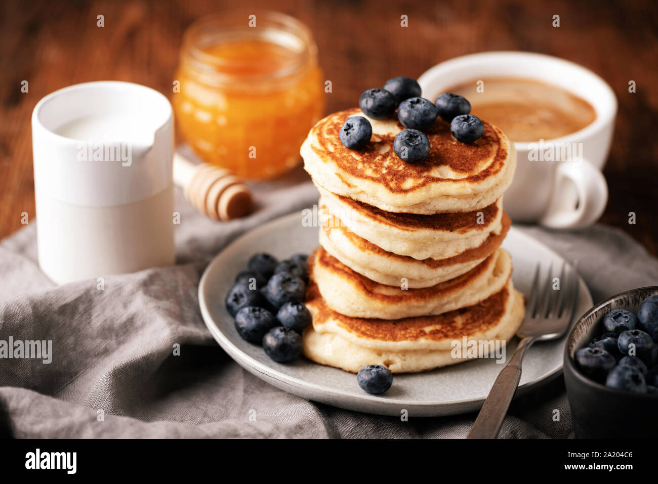 Pancake con mirtilli, caffè e miele. Pila di american latticello frittelle. Una gustosa prima colazione il cibo Foto Stock