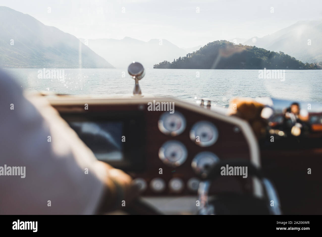 Il lago di Como mountain view attraverso la finestra di yacht. Sagome di colline sull orizzonte. Vacanze di lusso e concetto di crociera. Gita in barca. Yachting in Italia. Foto Stock